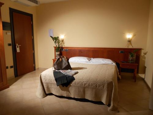 a hotel room with a bed with a purse on it at Magic Hotel in Atena Lucana