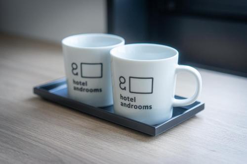two coffee mugs sitting on a tray on a table at hotel androoms Nagoya Fushimi in Nagoya