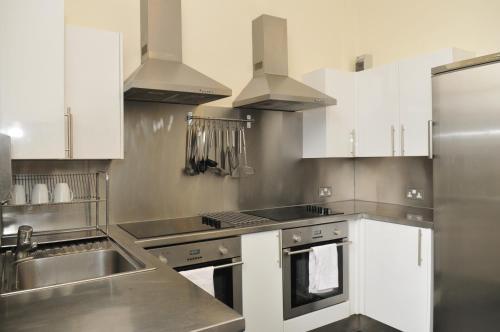 a kitchen with stainless steel appliances and white cabinets at The Hostel in Edinburgh