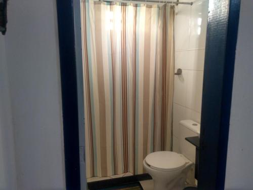 a bathroom with a shower curtain and a toilet at Casa em Cabo Frio in Cabo Frio