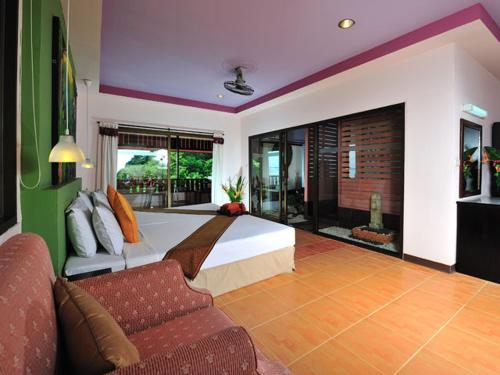 Koh Ngai Cliff Beach Resort في كو نغاي: غرفة نوم كبيرة مع سرير وأريكة