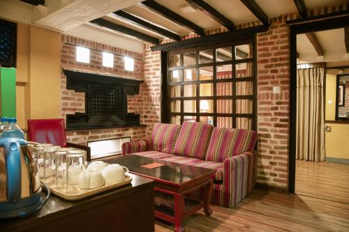 a living room with a couch and a fireplace at Nepal Pavilion Inn in Kathmandu