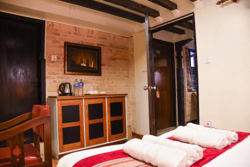 two beds in a room with a brick wall at Nepal Pavilion Inn in Kathmandu