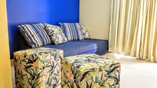 un sofá azul sentado en una sala de estar junto a una ventana en Linda Casa de Praia em Itacimirim, en Itacimirim