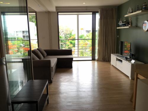 a living room with a couch and a television at บ้านแสนคราม หัวหิน Baan Sankraam Hua Hin Condominium in Hua Hin