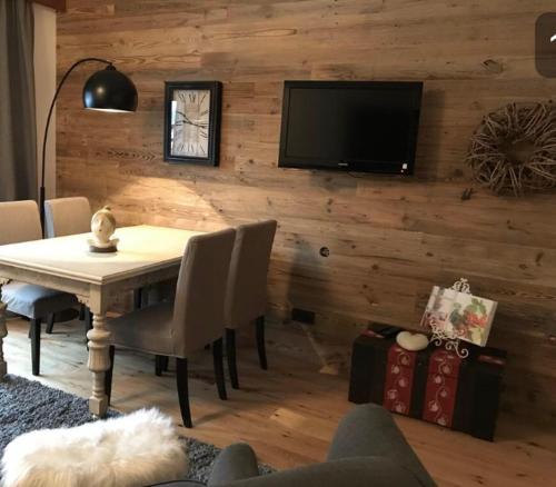 a dining room with a table and a tv on a wall at Gästehaus Weiherhof in Alpbach