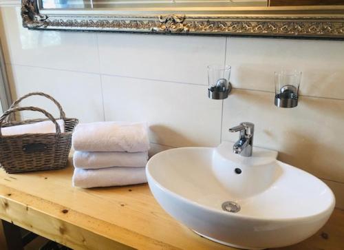 a bathroom with a sink and a mirror and towels at Gästehaus Weiherhof in Alpbach