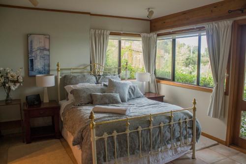 a bedroom with a bed and two windows at Titore Lodge in Russell