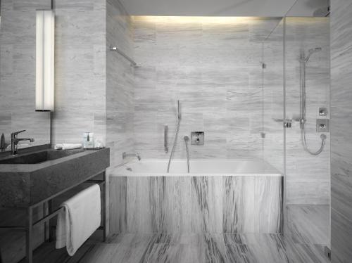 a bathroom with a tub and a sink and a shower at The Emblem Prague Hotel - Preferred Hotels & Resorts in Prague