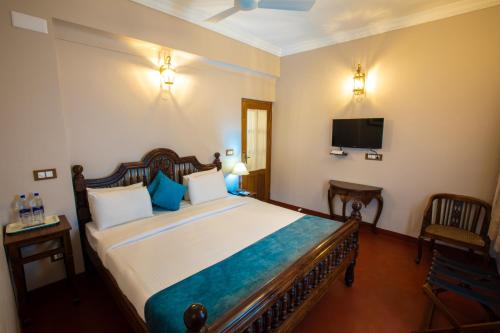 a bedroom with a large bed and a tv at 19VillaMira in Puducherry