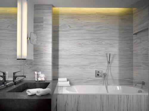 a bathroom with a tub and a sink at The Emblem Prague Hotel - Preferred Hotels & Resorts in Prague