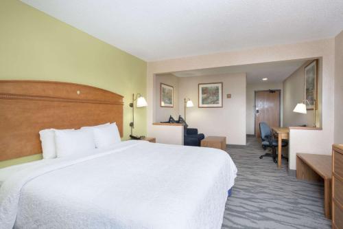 a hotel room with a large bed and a desk at Baymont by Wyndham Thornton in Thornton