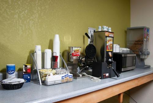 un bancone con macchinetta del caffè e cibo sopra di Super 8 by Wyndham Arkansas City KS ad Arkansas City