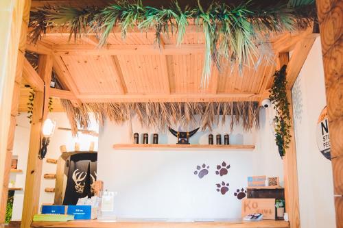 a room with a wooden ceiling and shelves with wine bottles at Kenting Original Hostel in Kenting