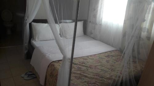 
A bed or beds in a room at Bondo Travellers Hotel
