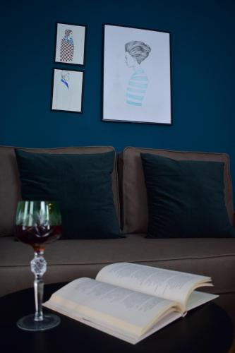 an open book on a table with a glass of wine at Beach Side Apart II in Kavala