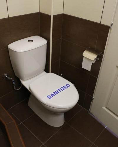 a bathroom with a toilet with a sign on it at Apartments & Dream Rooms in Niš