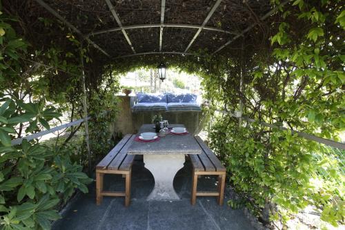 a wooden table in a garden with a bench at Quater Apartments - Tremezzina in Mezzegra