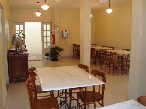 a dining room with tables and chairs in a room at Hotel Faisca in Mariana