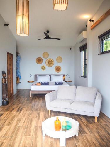 a living room with a couch and a bed at Mayara pool villas - Adults only in Haad Yao