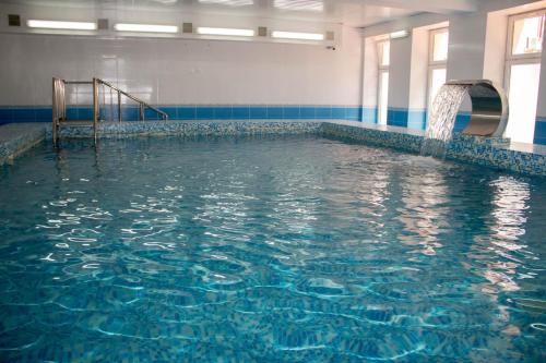 a pool of water with a water slide in it at Pyatigorskaya Klinika Sanatorium in Pyatigorsk