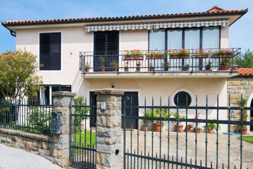ein Haus mit Topfpflanzen auf einem Balkon in der Unterkunft Mia resort in Izola