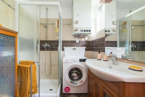 een badkamer met een wasmachine en een wastafel bij Mia resort in Izola