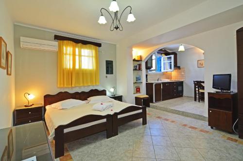 a bedroom with a bed and a living room at Nikos Sea View Apartments in Adamas