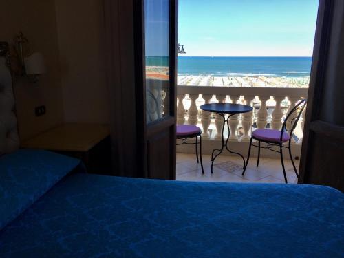 a bedroom with a bed and a view of the ocean at Villa Tina Hotel in Viareggio