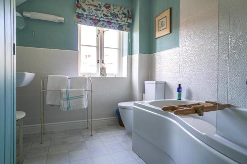 a bathroom with a tub and a toilet and a sink at 34 Grosvenor Drive in Tisbury