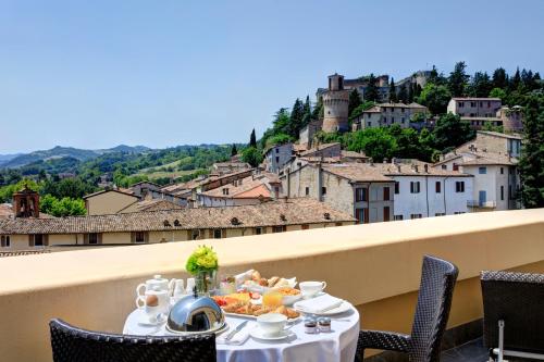 a table with a plate of food on a balcony at Grand Hotel Castrocaro Longlife Formula in Castrocaro Terme