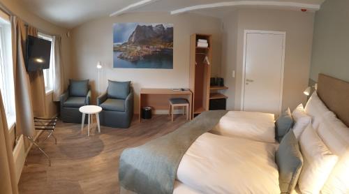a hotel room with a bed and two chairs at Strand Hotel Fevik - by Classic Norway Hotels in Fevik