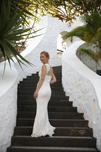a woman in a white dress standing on some stairs at Casuarina Resort and Spa in Trou aux Biches