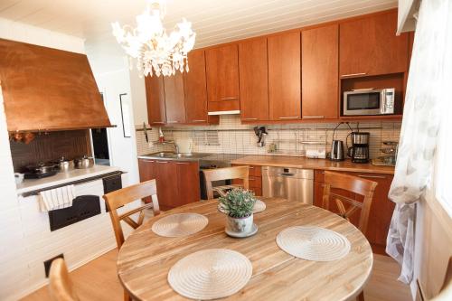 a kitchen with a wooden table with two plates on it at Villa de pikku Maria in Hamina