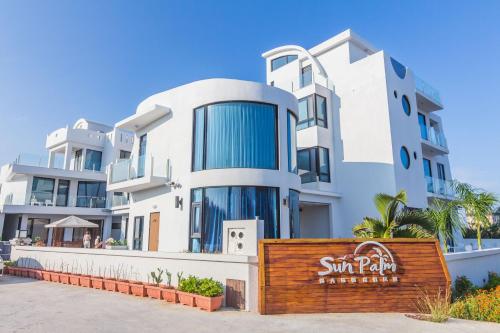 a large white building with a sign in front of it at Sunshine Palm B&B in Magong