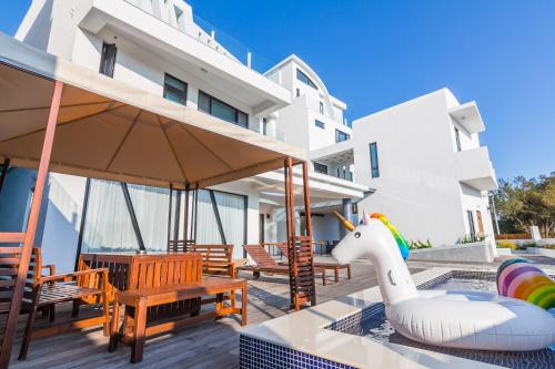 a patio with wooden chairs and an inflatable horse on a patio at Sunshine Palm B&B in Magong