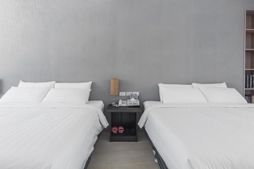 two beds sitting next to each other in a room at Sunshine Palm B&B in Magong