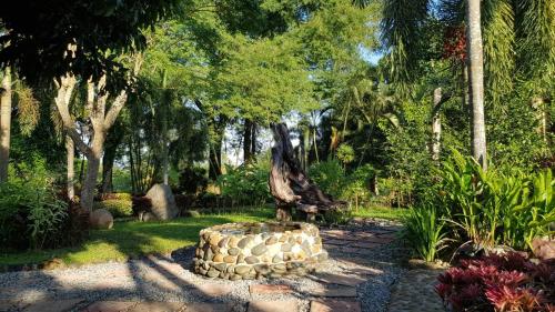 a statue of a tree sitting in a garden at Baan Sakuna Hotel in Chiang Khong