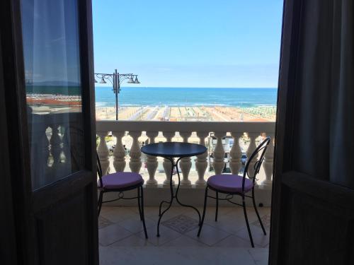 a balcony with a table and two chairs and the ocean at Villa Tina Hotel in Viareggio