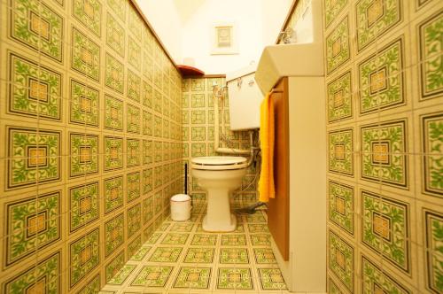 e bagno con servizi igienici e piastrelle bianche e verdi. di Tomato House Takayama a Takayama