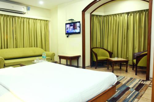 a hotel room with a bed and a tv at Garden Hotel in Mumbai
