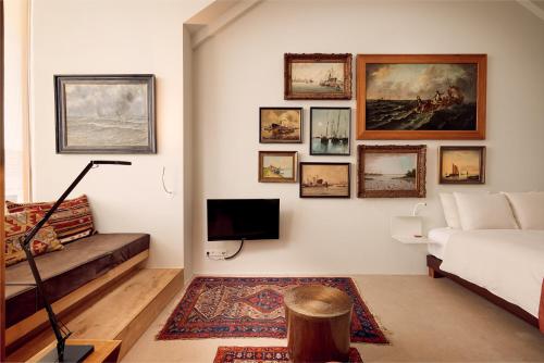 a living room with a couch and pictures on the wall at Hotel Miss Blanche in Groningen