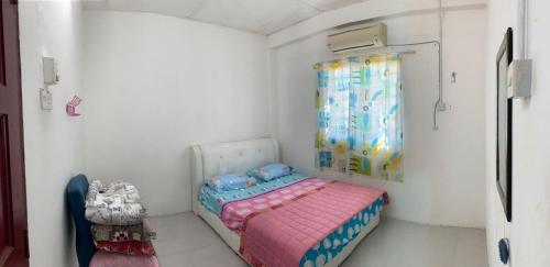 a small bedroom with a bed and a window at Homestay Villa Teluk Batik in Lumut