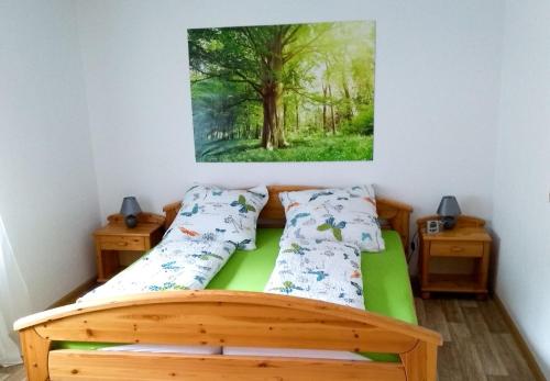 - une chambre avec un lit en bois et une peinture murale dans l'établissement Ferienwohnung Am Eichbühl, à Waldkirch