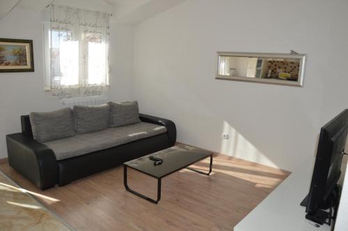 a living room with a black couch and a table at Apartments Babic in Podstrana