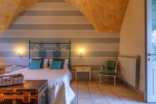 a bedroom with a bed and a chair at Masseria Sorani in Manduria