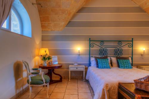 a bedroom with a bed and a table and a chair at Masseria Sorani in Manduria