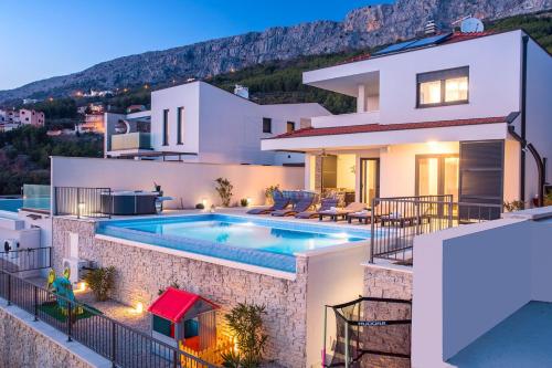 Bazén v ubytování Villa Nano, 4 bedrooms, jacuzzi, heated pool, sea views, pebble beach 850m nebo v jeho okolí