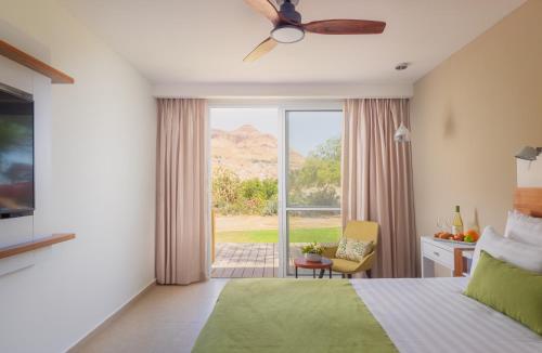 a bedroom with a bed and a large window at Ein Gedi Kibbutz Hotel in Ein Gedi