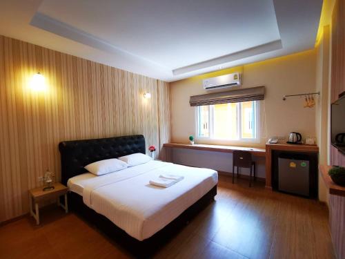 a hotel room with a bed and a window at Triple Trees Hotel in Pathum Thani
